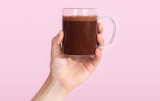 Spacegoods rainbow dust in a mug held by a hand