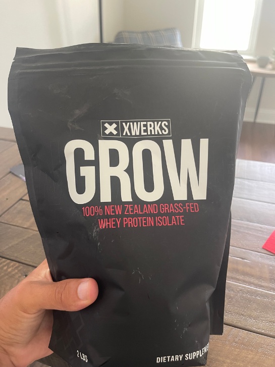 Protein powder XWERKS Grow being held by a  hand