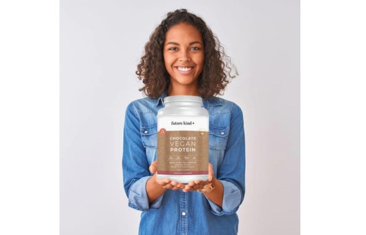 vegan protein powder by future kind chocolate flavor being held by a woman